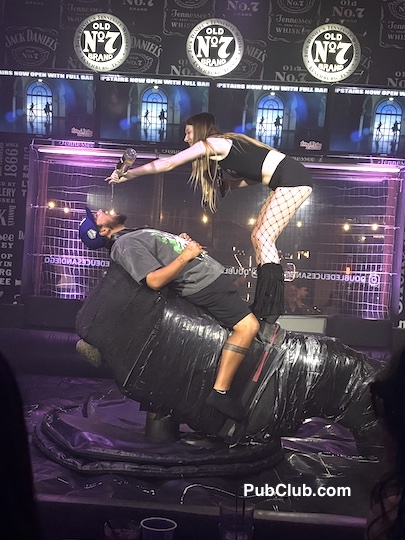 girl gives guy a shot on a mechanical bull at Double Deuce San Diego girl gives guy a shot on a mechanical bull at Double Deuce San Diego