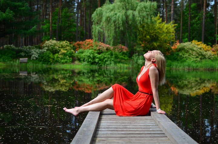 girl sitting on a dock at a lake