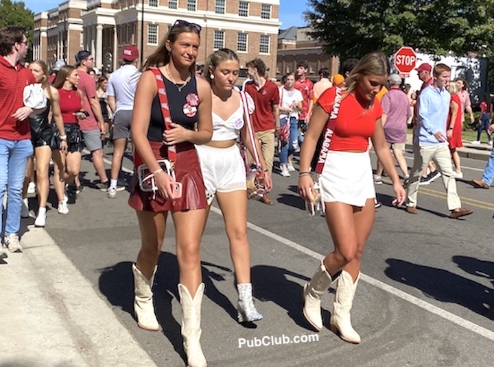three girls wear cowboy boots at an SEC football game